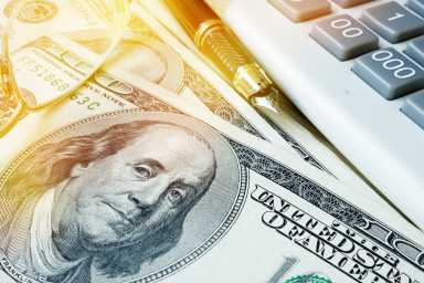 Home finances concept. Savings in dollars, calculator and pen.